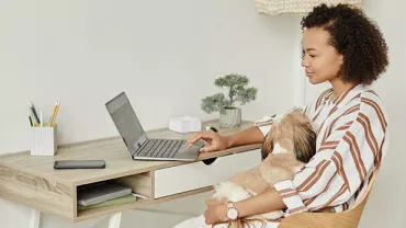 Kobieta pracująca zdalnie na laptopie w swoim domowym biurze. 