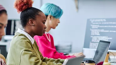 Gen Z at work on laptops in a modern office.